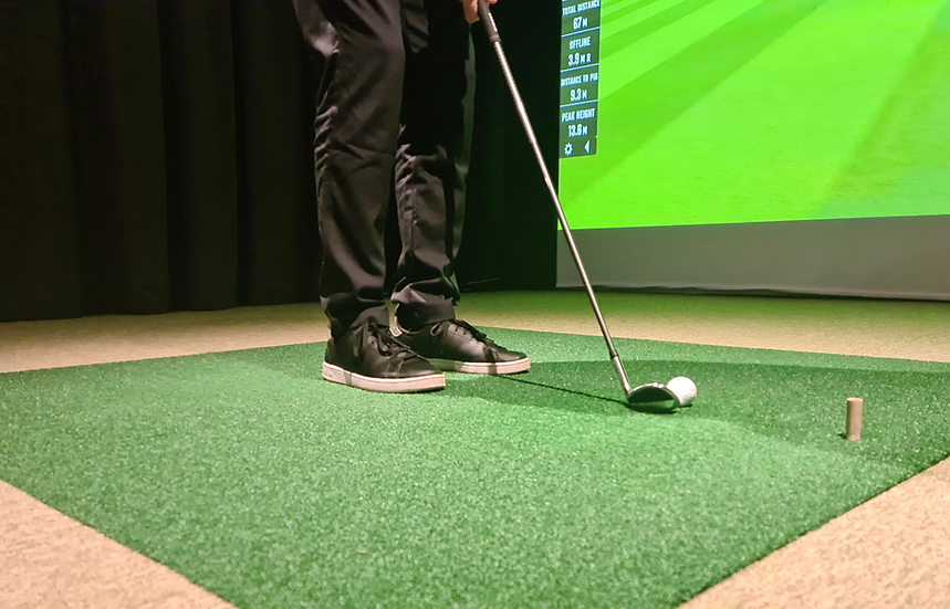 Adult playing on an indoor golf simulator at Let's Play in Delta, BC